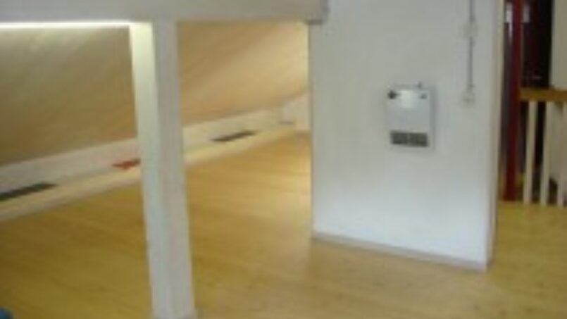 Leeres Zimmer mit Holzboden und Holzdecke in der Gruppenunterkunft Jungwachtferienhaus Klingenzell in Eschenz