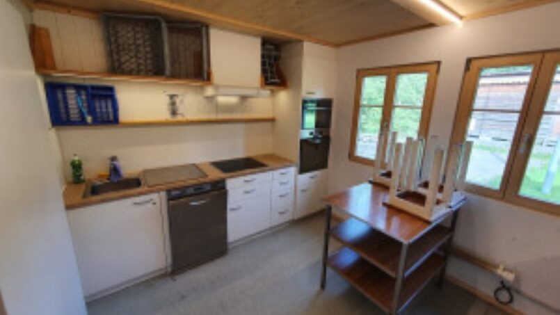 Kleine Küche mit Herd und Spüle im Gruppenhaus Kadettenhütte in Winterthur