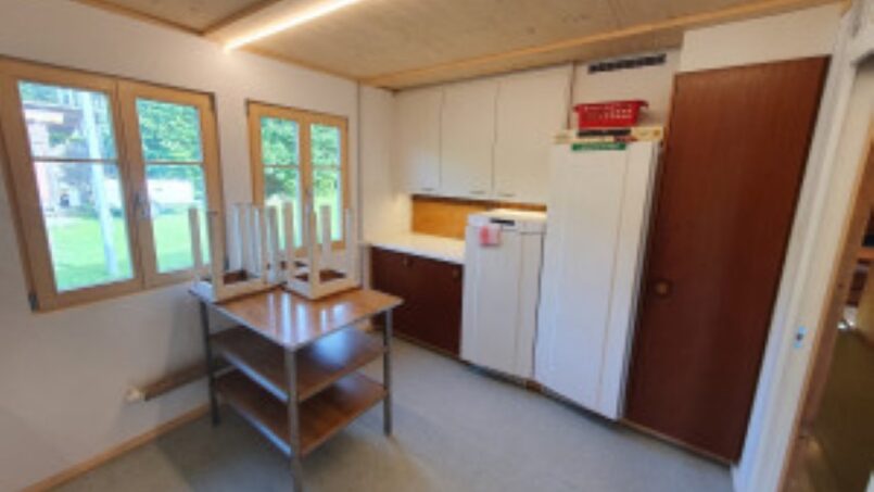 Kleine Küche mit Kühlschrank und Spüle im Gruppenhaus Kadettenhütte Winterthur
