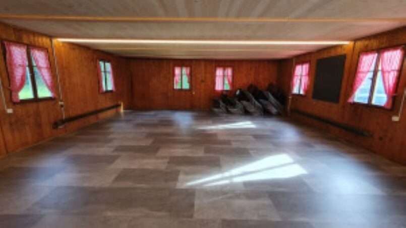 Leeres Zimmer in Gruppenhaus Kadettenhütte Winterthur mit Holzwänden und Fenstern