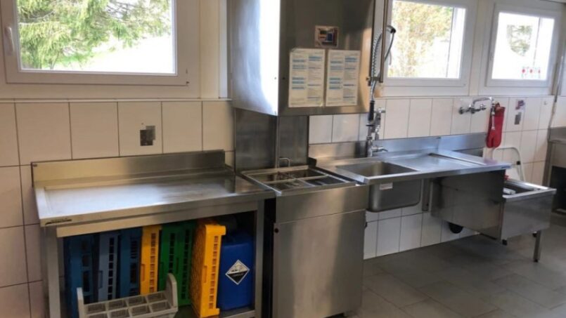 Edelstahl-Küche-mit-Spülbecken-und-Kühlschrank-im-Gruppenhaus-Le-Refuge-Mont-Tramelan