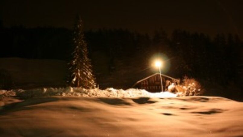Gruppenhaus Les Flaches in Grimentz bei Nacht mit schneebedecktem Hügel