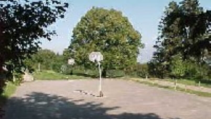 Gruppenhaus Monteret I in Saint-Cergue mit Basketballplatz umgeben von Bäumen und Büschen