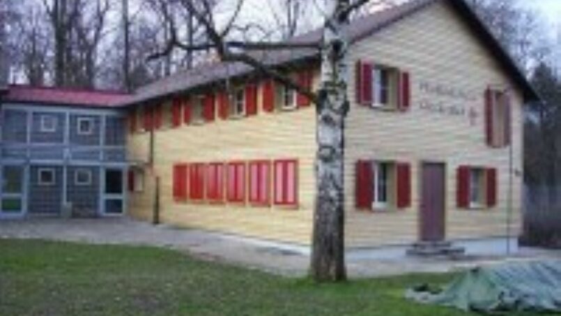 Gruppenhaus-Pfadiheim-Wallisellen-Holzhaus-mit-roten-Läden-im-Wald