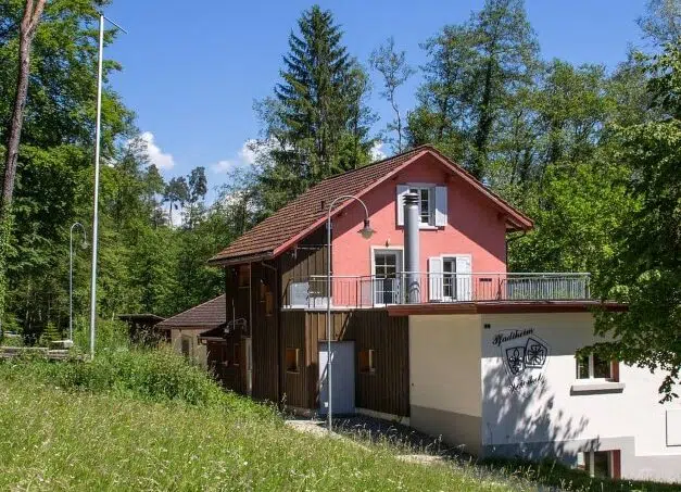 Gruppenhaus Pfadiheim Weierholz in Pfäffikon umgeben von Wald mit rosa Dach