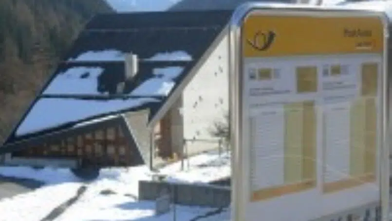 Gruppenhaus Schulhaus Ferden im Winter mit schneebedecktem Schild