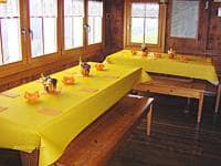 Gelbe Tischdecke auf Holztisch im Gruppenhaus Ski- und Clubhaus Pfungen in Ebnat-Kappel