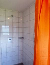 Gruppenhaus Ski- und Clubhaus Pfungen in Ebnat-Kappel Badezimmer mit orangenem Duschvorhang