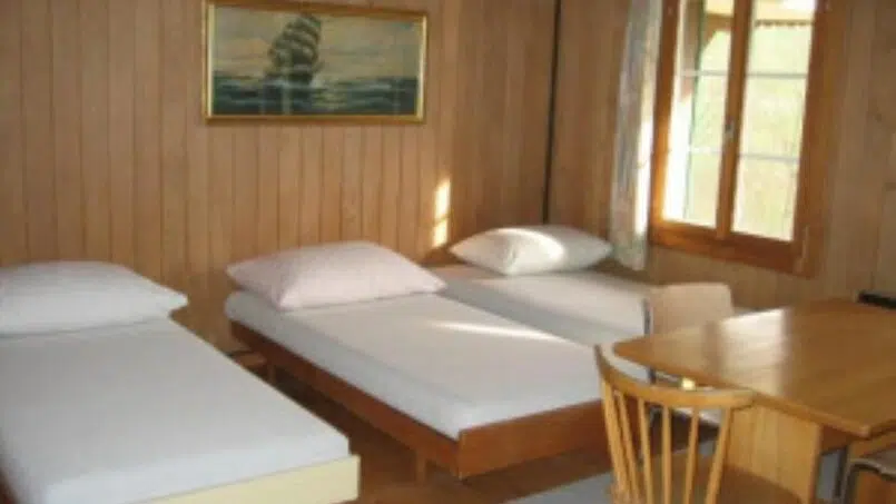 Zwei Betten in einem Zimmer mit Holzverkleidung im Gruppenhaus Sunneheim Wyssachen