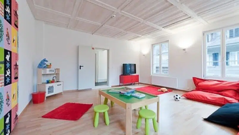 Kinderzimmer im Gruppenhaus Teamhaus Boltigen mit buntem Teppich und Spielzeug