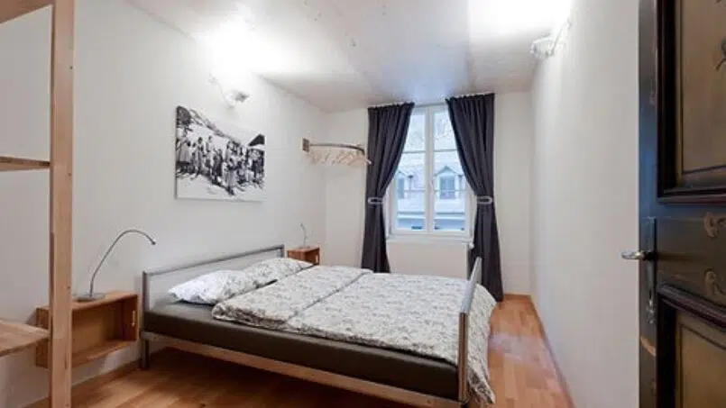 Schlafzimmer im Gruppenhaus Teamhaus in Boltigen mit Holzboden und Bett