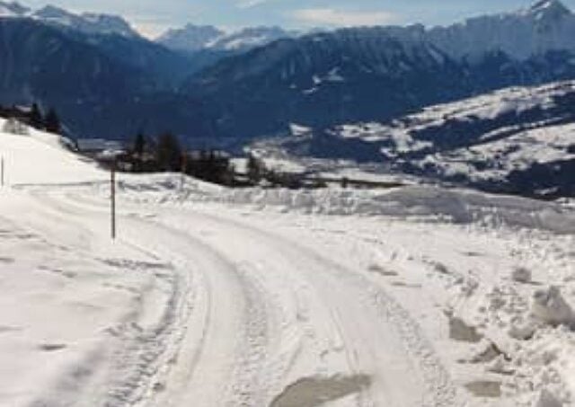 Schneebedeckter Weg mit Bergen, Ferienlagerhaus, Trans Gruppenunterkunft