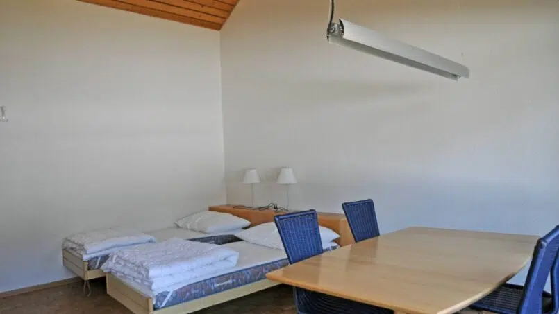 Kleines Zimmer mit Bett und Tisch im Frauenfelderhaus Wildhaus - Gruppenunterkunft