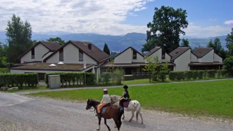 Zwei Personen reiten Pferde vor Gruppenunterkunft Jugendhaus Heilsarmee in Stäfa