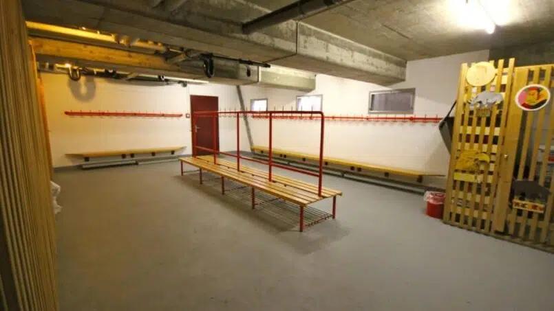 Gruppenunterkunft-Jugendhaus-Heilsarmee-Stäfa-Umkleideraum-mit-Bänken-rote-Wand
