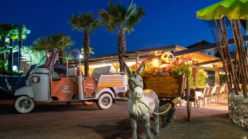 Esel zieht Wagen vor Restaurant beim Gruppenhaus Bamboohouse Motel Riazzino in Riazzino