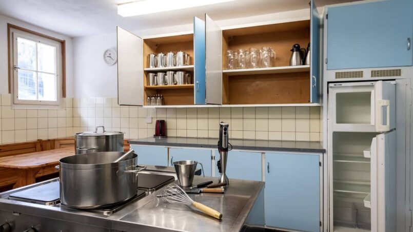 Gruppenunterkunft Casa Clau Rueun - Küche mit blauen Schränken und Herd