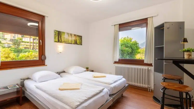 Kleines Schlafzimmer mit zwei Betten im Bamboohouse Motel Riazzino, Gruppenhaus in Riazzino