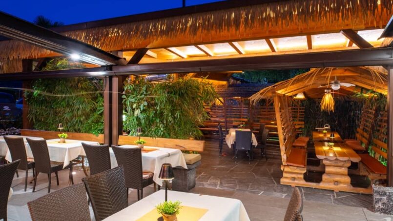 Restaurant des Gruppenhaus Bamboohouse Motel Riazzino mit Außenbestuhlung bei Nacht