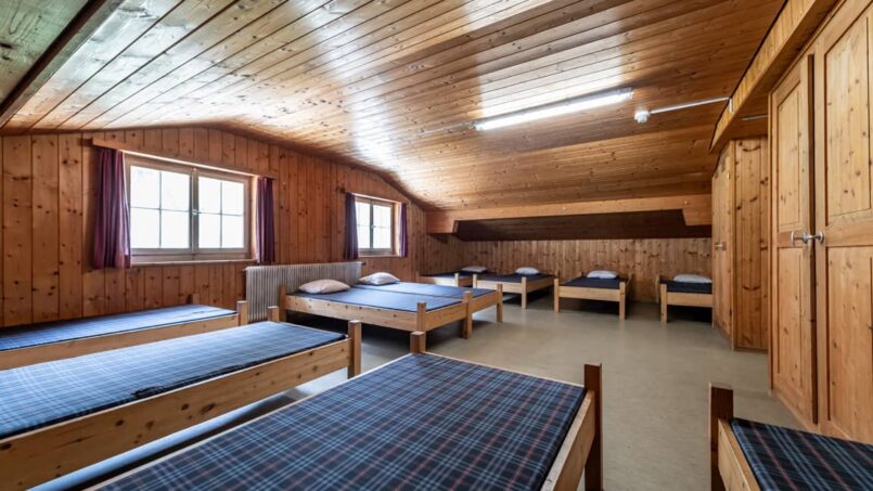 Gruppenunterkunft Casa Clau Rueun - Zimmer mit Etagenbetten in einer Holzhütte
