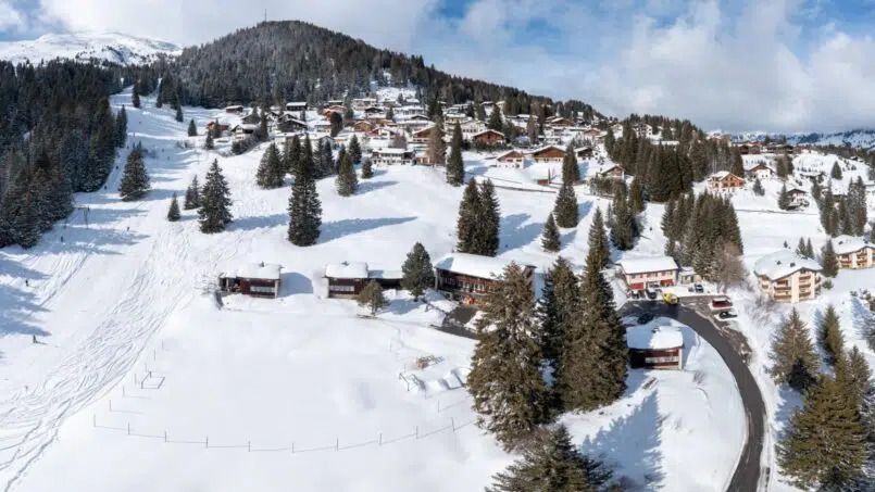 Gruppenunterkunft Hinwilerhuus Valbella Luftaufnahme verschneites Dorf Schweizer Alpen