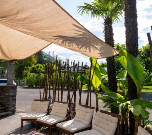 Gruppenhaus Bamboohouse Motel Riazzino mit schattiger Terrasse und Lounge-Stühlen