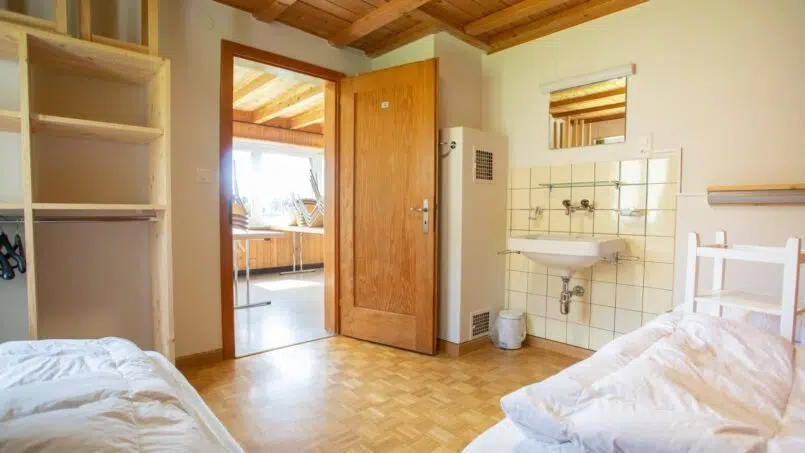 Zweibettzimmer mit Waschbecken im Gruppenunterkunft Hinwilerhuus Valbella