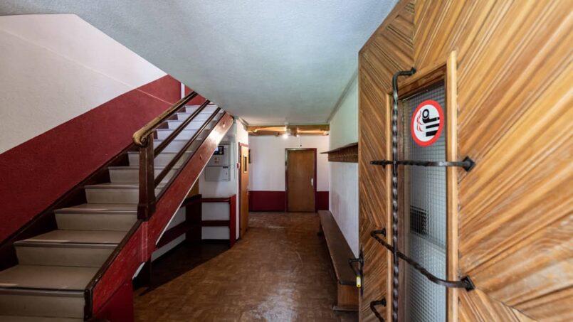 Gruppenunterkunft Casa Clau Rueun - Flur mit Treppe und rot-weissen Wänden