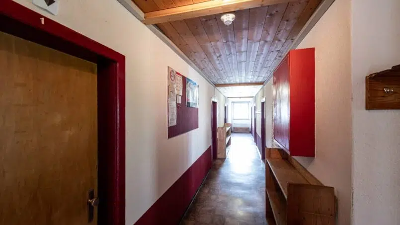 Roter Flur mit Holzboden im Gruppenunterkunft Casa Clau in Rueun