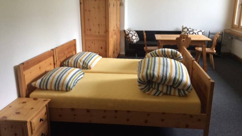 Kleines Schlafzimmer mit Bett und Tisch in Casa Sentupada, Gruppenunterkunft in Siat