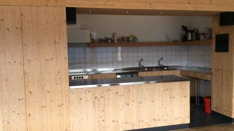 Gruppenunterkunft Casa Sentupada Siat, Küche mit Holzschränken und Wanduhr