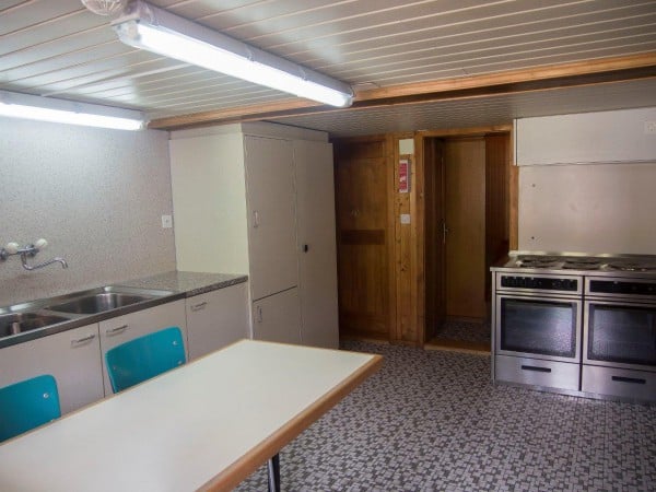 Kleine Küche mit Herd und Spülbecken im Gruppenhaus Hari's Chalets Nr. 1 - 6 in Adelboden - Gruppenunterkunft Schweiz