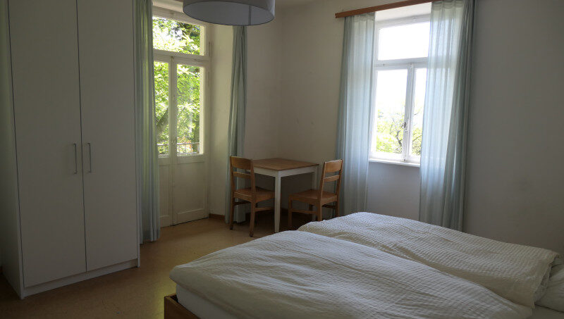 Gruppenhaus La Pineta Schlafzimmer mit Bett und Fenster in Locarno