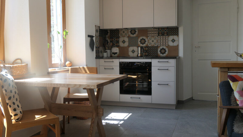 Kleine Küche mit Tisch und Stühlen im Gruppenhaus La Pineta in Locarno