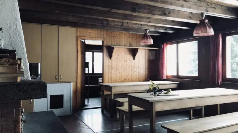 Gruppenhaus Pfadiheim Parmort Madris-Vermol Küche mit Holztischen und -bänken