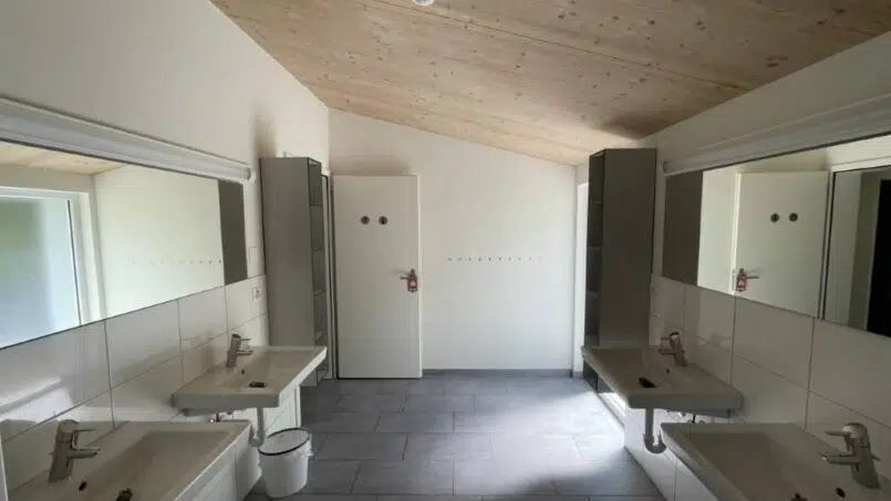 Gruppenunterkunft Clubhaus Alt St. Johann Badezimmer mit zwei Waschbecken und Spiegel