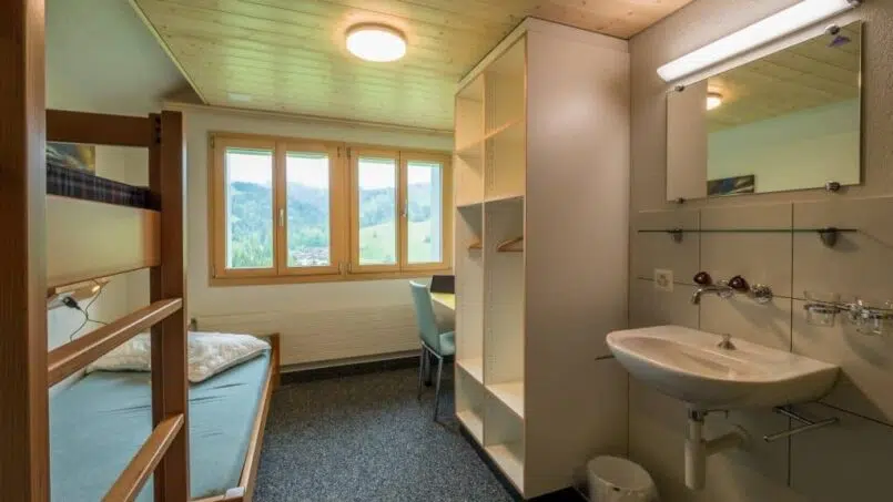 Kleines Zimmer mit Etagenbetten und Waschbecken im CVJM Ferienheim Rothornblick Flühli, Gruppenunterkunft