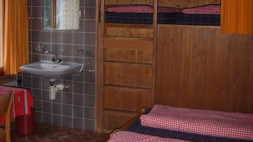 Gruppenunterkunft Jugendhaus Ramsern Beatenberg kleiner Schlafraum mit zwei Stockbetten und Waschbecken.