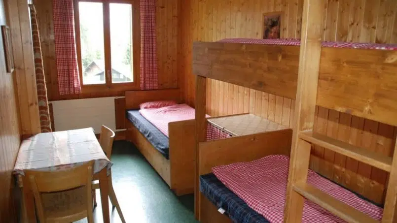 Kleines Zimmer mit Etagenbetten und Tisch im Jugendhaus Ramsern, Beatenberg - Gruppenunterkunft