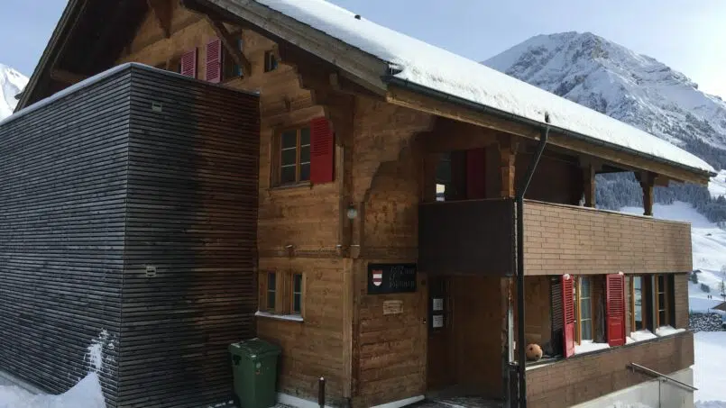 Gruppenhaus Sonnenrain in Adelboden - Holzgebäude mit schneebedecktem Dach
