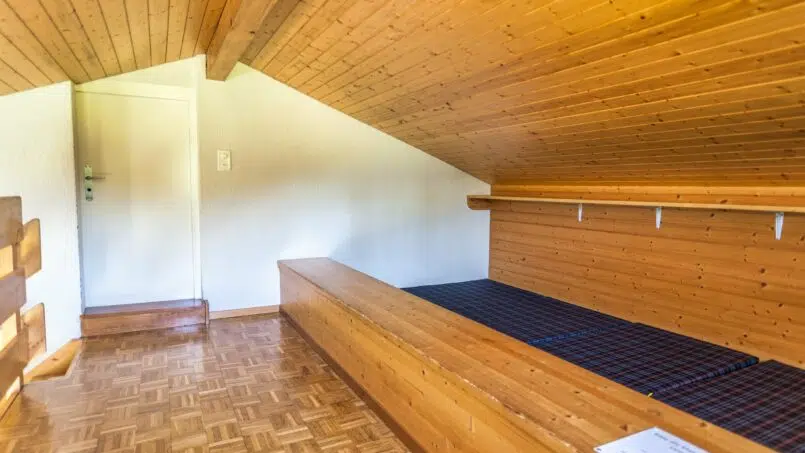 Gruppenhaus Pfadiheim Reiden kleines Zimmer mit Holzboden und Bett