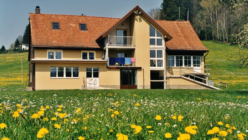 Gruppenhaus Pfadiheim Hinterberg in Andwil umgeben von gelben Löwenzahnfeldern
