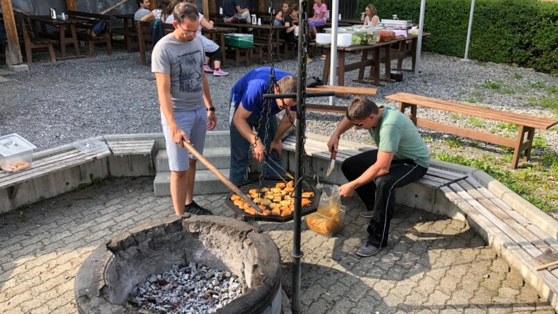 Gruppe von Menschen am Feuerplatz vor Gruppenhaus Weißes Haus in Beatenberg