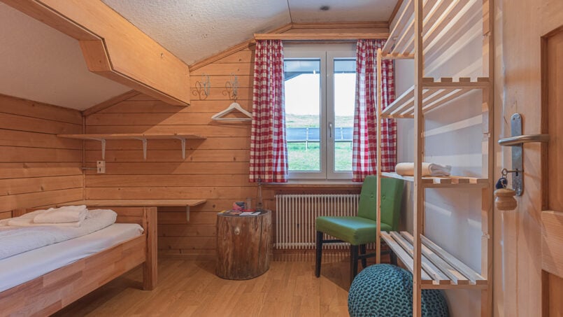 Gruppenhaus Berghaus Niederhorn Beatenberg kleines Zimmer mit Bett und Stuhl
