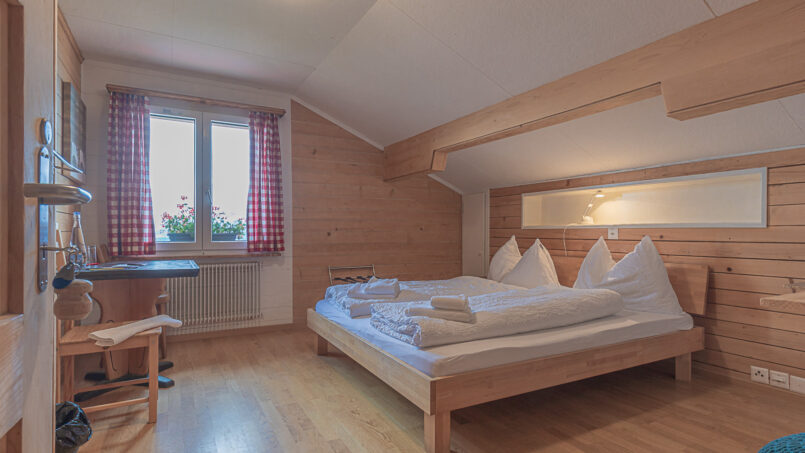 Gruppenhaus Berghaus Niederhorn Beatenberg - Schlafzimmer mit Bett und Schreibtisch