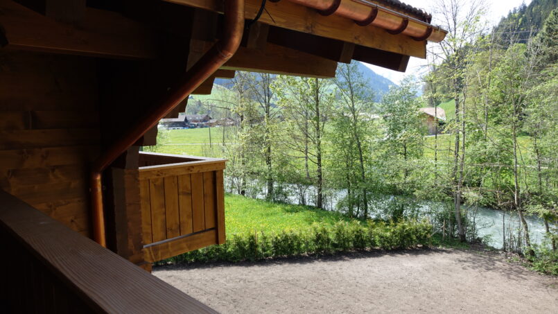 Gruppenhaus-Sportlodge-Gstaad-Holzgebäude-mit-Flussblick