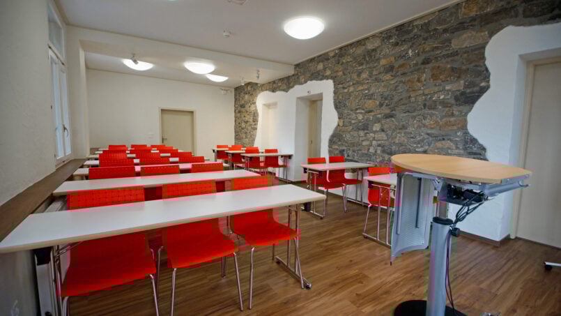 Gruppenhaus Beatenberg Weisses Haus - Zimmereinrichtung mit Tischen und Stühlen.