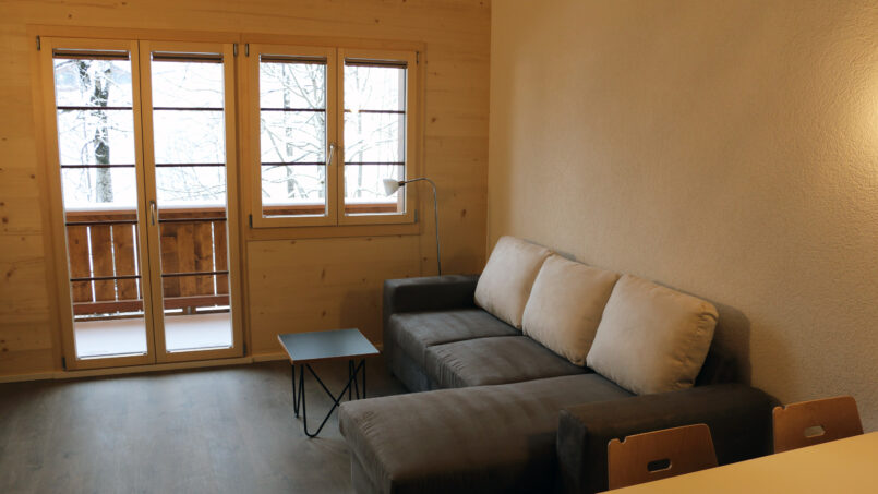 Gruppenhaus Sportlodge Gstaad - Wohnzimmer mit Couch und Tisch