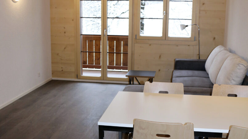 Gruppenhaus Sportlodge Gstaad Zimmer mit Tisch und Stühlen