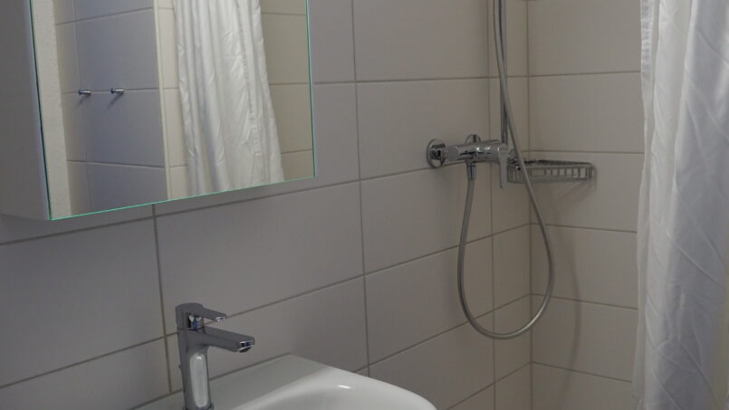 Badezimmer mit Dusche und Waschbecken im Gruppenhaus Sportlodge Gstaad.